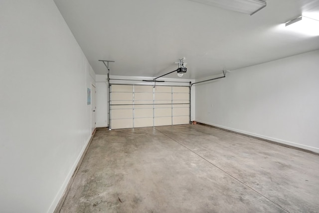 garage featuring a garage door opener and baseboards