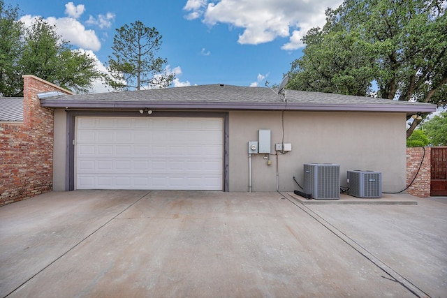 garage with concrete driveway and central AC unit