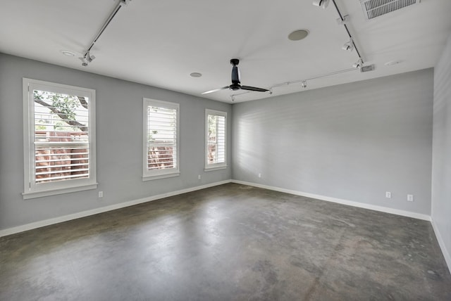 unfurnished room featuring track lighting, a healthy amount of sunlight, visible vents, and finished concrete flooring