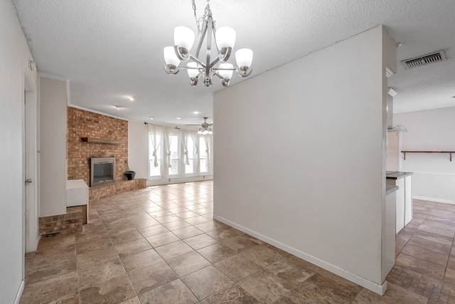 unfurnished living room featuring tile patterned flooring, visible vents, a brick fireplace, ceiling fan with notable chandelier, and a textured ceiling