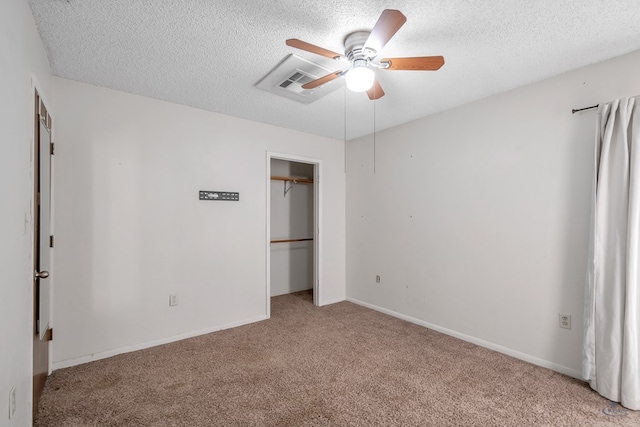 unfurnished bedroom featuring baseboards, visible vents, a closet, a textured ceiling, and light carpet