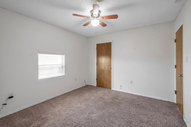 unfurnished room with carpet, a ceiling fan, and a textured ceiling