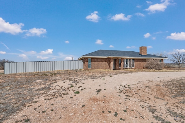 back of property featuring brick siding and a chimney