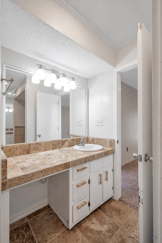 bathroom featuring a textured ceiling, vanity, and crown molding