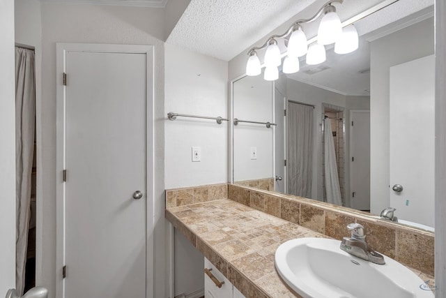 bathroom with vanity, a textured ceiling, and ornamental molding