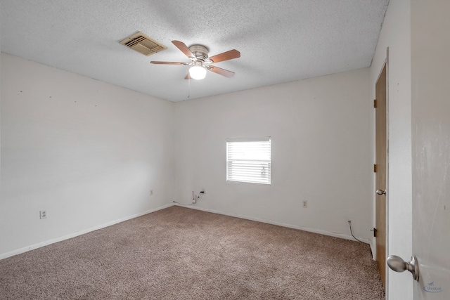 carpeted spare room with baseboards, visible vents, a textured ceiling, and ceiling fan