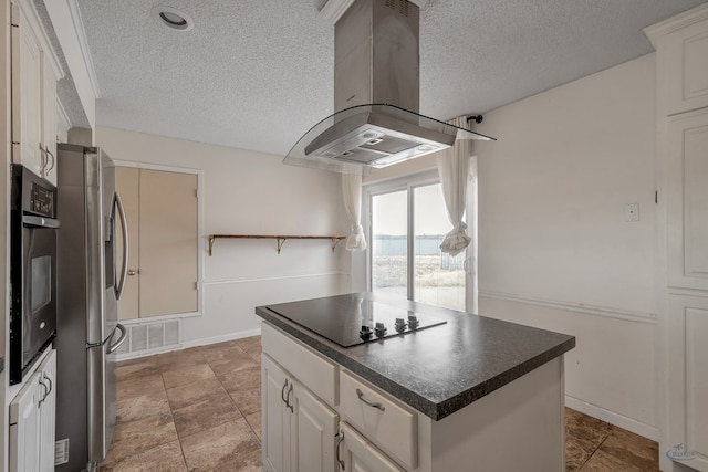 kitchen featuring dark countertops, a kitchen island, island range hood, white cabinets, and black appliances