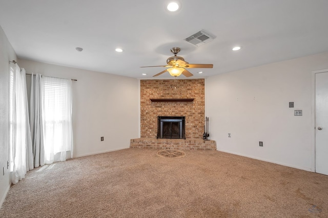 unfurnished living room with recessed lighting, carpet flooring, a fireplace, and visible vents