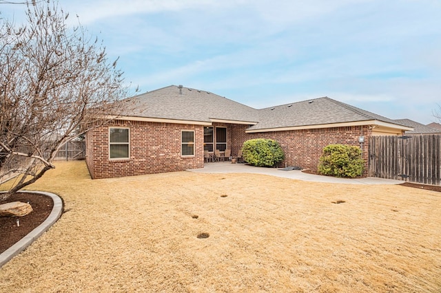 back of property with a yard and a patio area