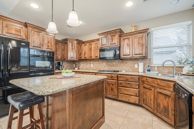 kitchen with decorative light fixtures, sink, decorative backsplash, and black appliances