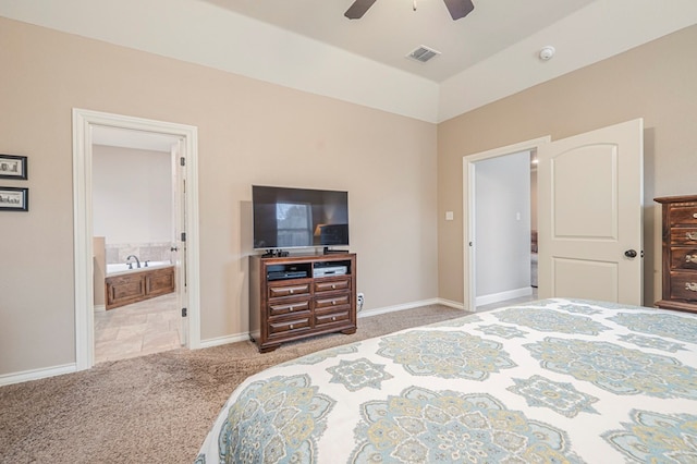 bedroom with ceiling fan, ensuite bathroom, and light carpet