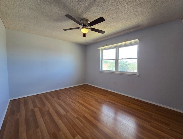 spare room featuring wood finished floors, a textured ceiling, ceiling fan, and baseboards