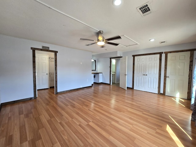 unfurnished living room featuring attic access, ceiling fan, baseboards, light wood-style floors, and recessed lighting