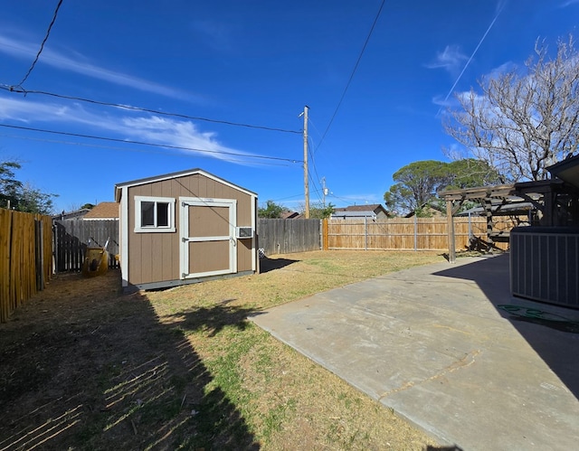 view of yard with central AC unit, a patio area, a storage shed, and an outbuilding