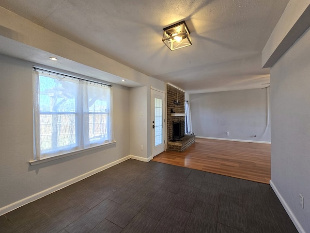 unfurnished living room featuring a brick fireplace, baseboards, wood finished floors, and recessed lighting
