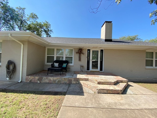 3501 Austin Pl, Snyder, TX 79549 - back of property featuring brick siding, roof with shingles, a patio, and a chimney