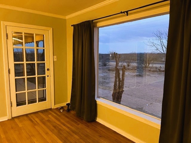 unfurnished room featuring baseboards, ornamental molding, and wood finished floors