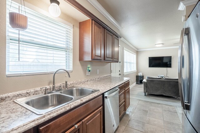 1829 Petroleum Dr, Odessa, TX 79762 - kitchen featuring appliances with stainless steel finishes, a sink, open floor plan, ornamental molding, and light countertops