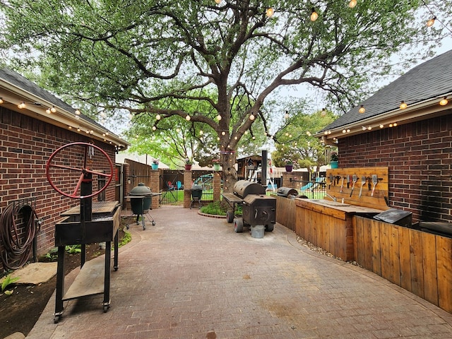view of patio featuring a fenced backyard, a playground, and grilling area