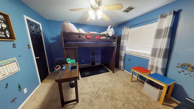 carpeted bedroom featuring visible vents, a textured ceiling, and ceiling fan
