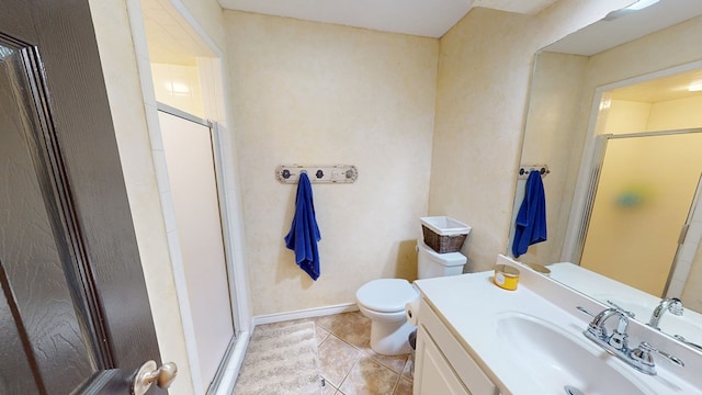 bathroom featuring vanity, tile patterned flooring, a shower stall, and toilet