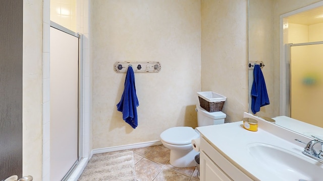 bathroom with tile patterned flooring, a stall shower, vanity, baseboards, and toilet