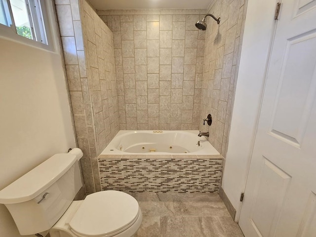 bathroom featuring tiled shower / bath combo and toilet