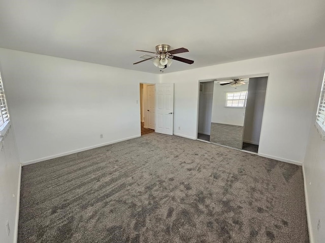 unfurnished bedroom featuring ceiling fan, dark carpet, and a closet