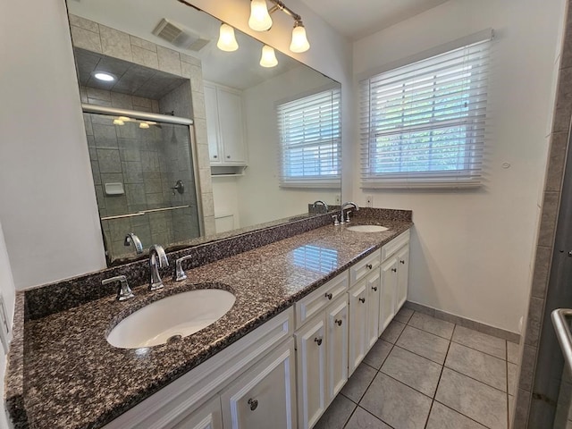 bathroom featuring tile patterned floors, vanity, and a shower with door