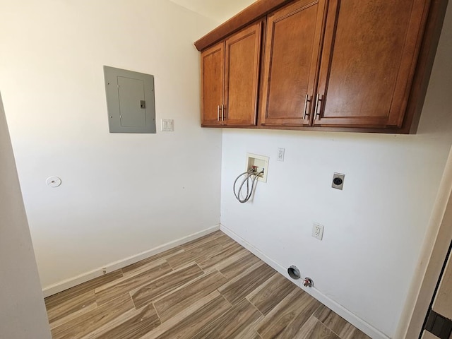 clothes washing area featuring cabinets, electric dryer hookup, hookup for a gas dryer, electric panel, and hookup for a washing machine