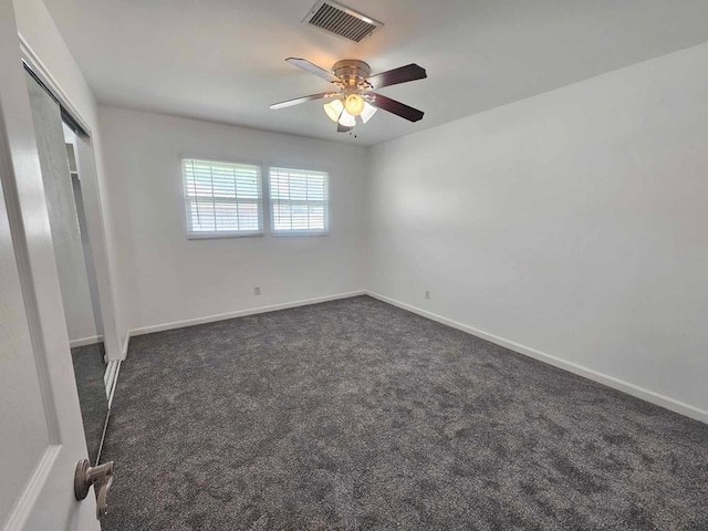 unfurnished bedroom featuring ceiling fan, a closet, and dark colored carpet