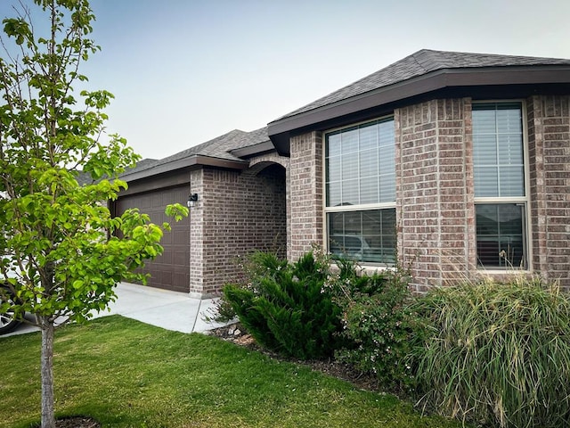 607 Foggy Bottom Ct, Midland, TX 79706 - view of property exterior with an attached garage, brick siding, a lawn, and a shingled roof
