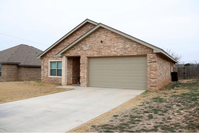 ranch-style house with driveway, brick siding, and an attached garage