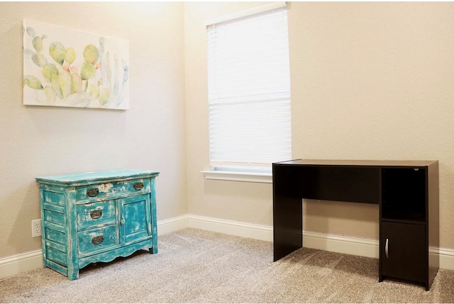 unfurnished office featuring light carpet and baseboards