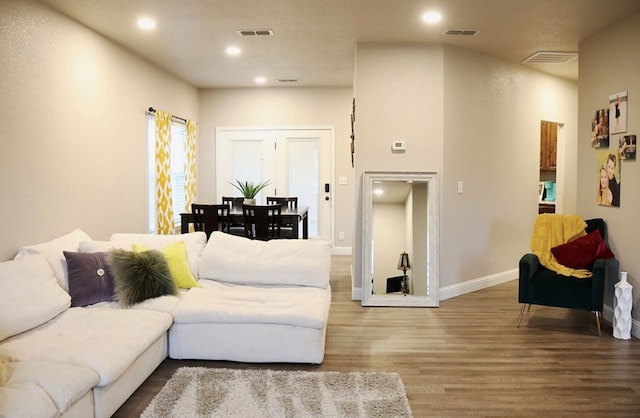 living area featuring recessed lighting, visible vents, baseboards, and wood finished floors