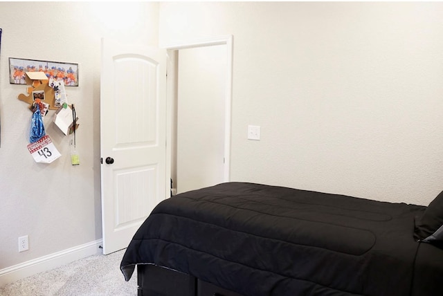 bedroom with light carpet and baseboards