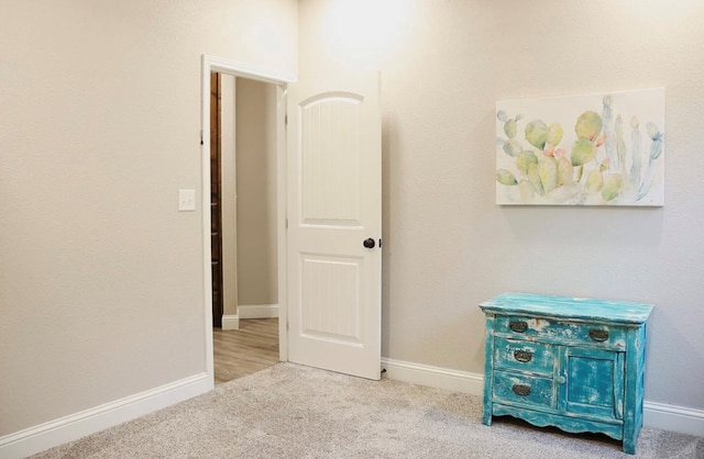 interior space featuring light carpet and baseboards