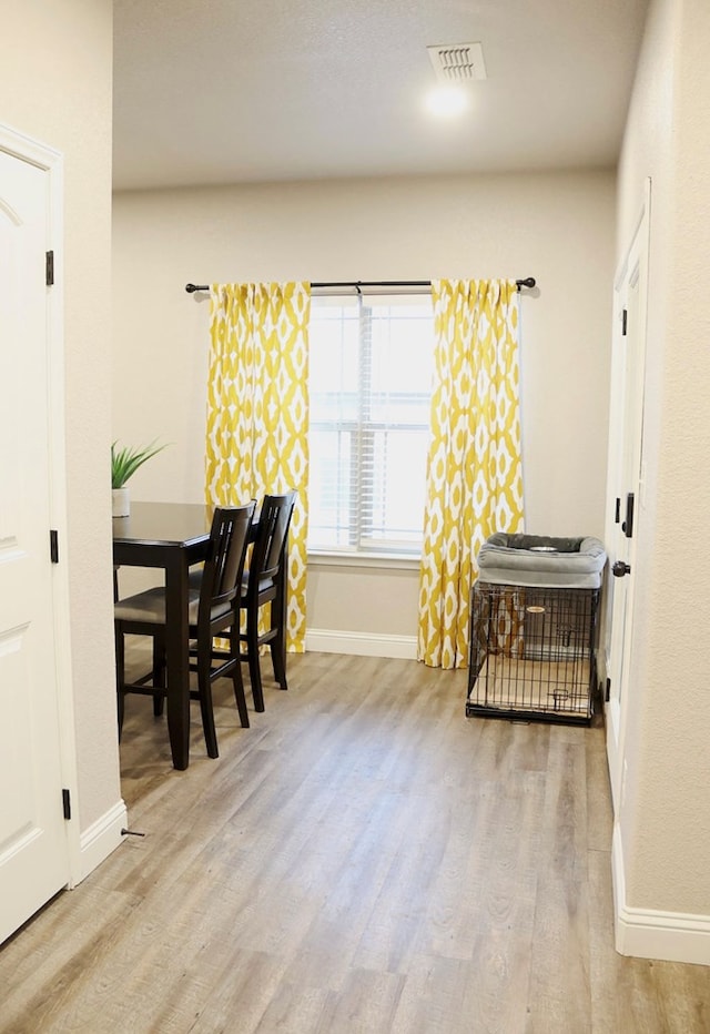 dining area with baseboards, visible vents, and wood finished floors