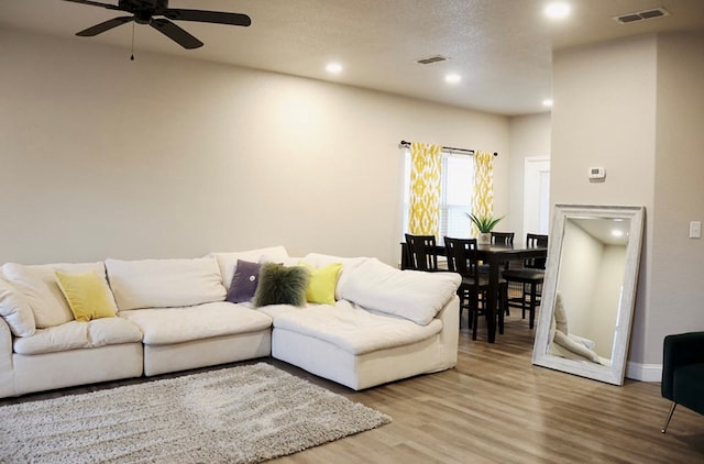 living area with a ceiling fan, visible vents, wood finished floors, and recessed lighting