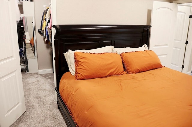 bedroom featuring baseboards and light colored carpet