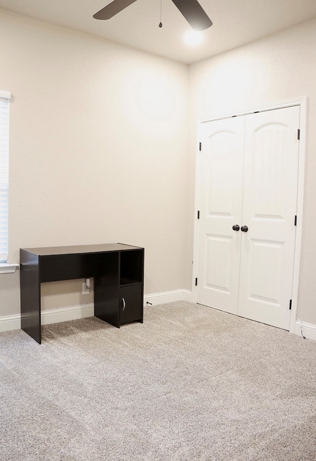 unfurnished bedroom with carpet floors, ceiling fan, baseboards, and a closet