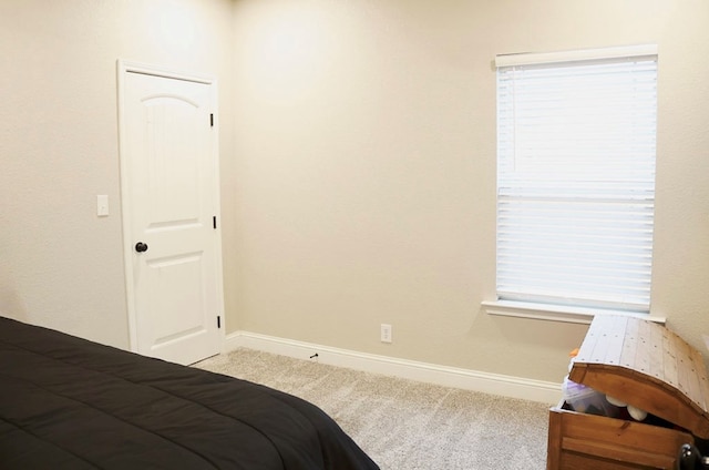 carpeted bedroom featuring baseboards