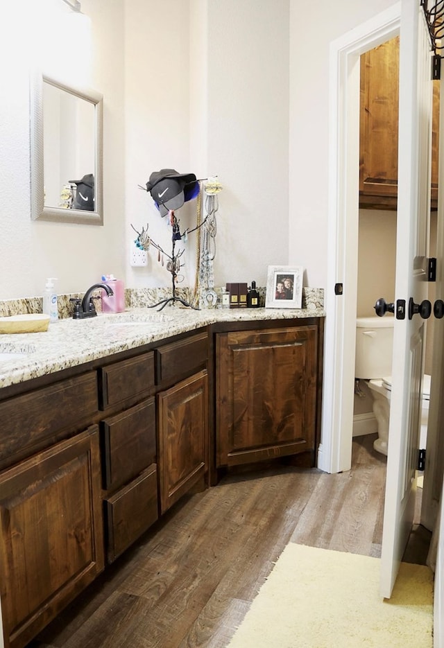 bathroom with vanity, wood finished floors, and toilet