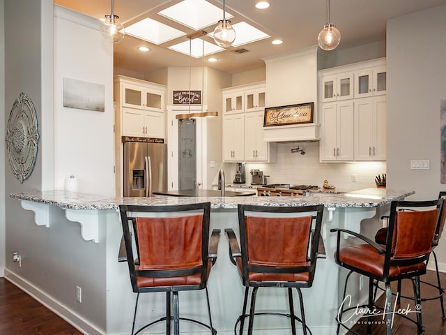 5300 Balfour Ct, Midland, TX 79707 - kitchen with stainless steel refrigerator with ice dispenser, a skylight, dark wood-style floors, backsplash, and recessed lighting
