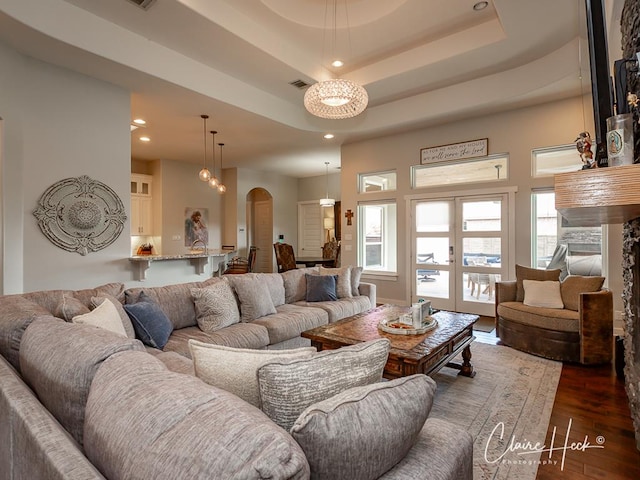 5300 Balfour Ct, Midland, TX 79707 - living area featuring arched walkways, dark wood-type flooring, a tray ceiling, and recessed lighting