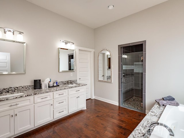 5300 Balfour Ct, Midland, TX 79707 - bathroom featuring double vanity, a shower stall, wood finished floors, a bathtub, and recessed lighting