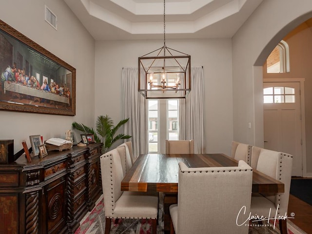 5300 Balfour Ct, Midland, TX 79707 - dining area featuring arched walkways, a chandelier, and a tray ceiling