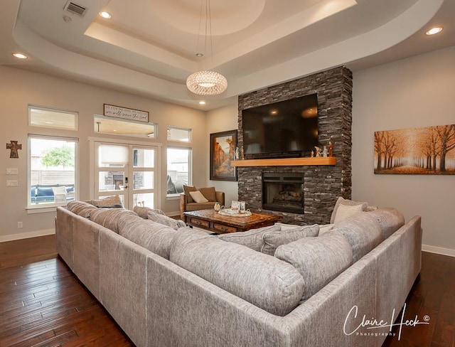5300 Balfour Ct, Midland, TX 79707 - living area featuring a raised ceiling, dark wood-style floors, a stone fireplace, and recessed lighting