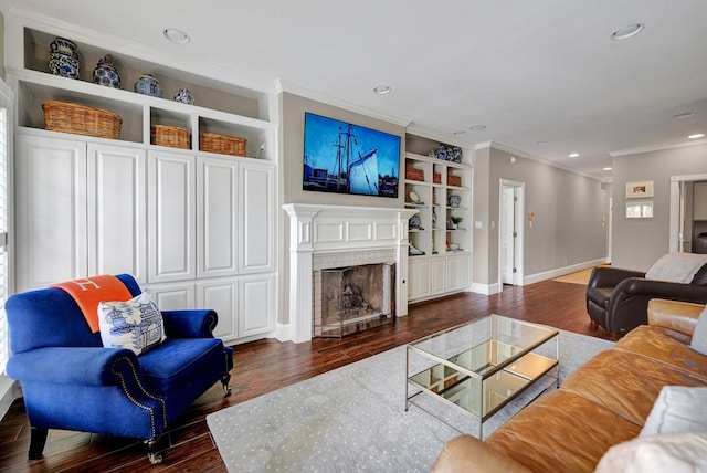 living room featuring a brick fireplace, ornamental molding, built in features, and wood finished floors