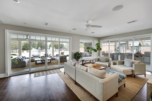 living area featuring a ceiling fan, wood finished floors, and visible vents